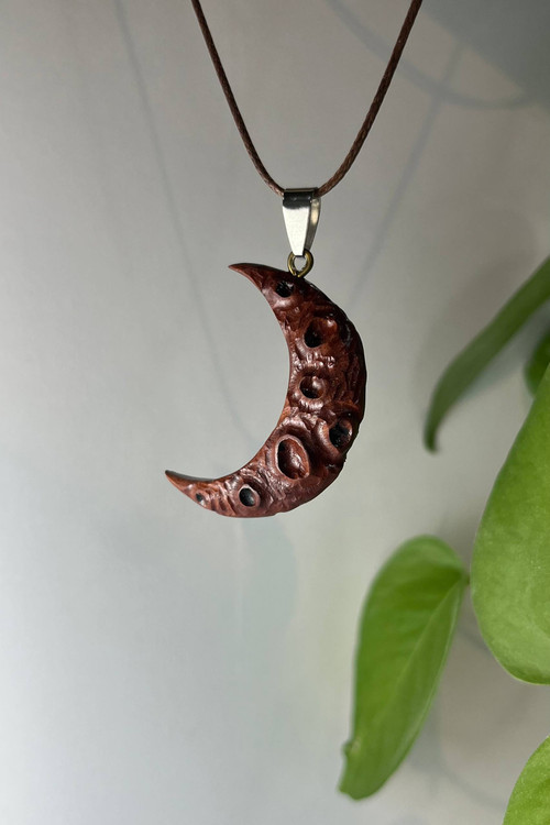 گردنبندماه ، ساختهشده از چوب طبیعی در کارگاه ملورینا؛ نمادی از امید، حفاظت و رهایی. هدیهای دستساز و خاص برای کسانی که به نور ایمان دارند.