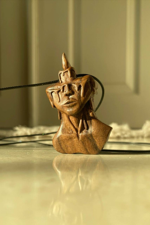 گردنبند چوبی مفهومی طرح چهره و شمع در حال ذوب (اشکساز) حکاکی شده روی چوب گردو، اثر ملوریناوود